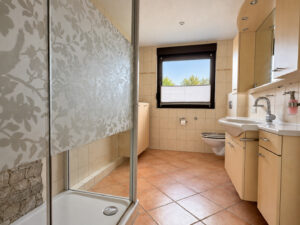 Badezimmer mit flacher Dusche und praktischem Stauraum